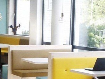 Lichte werkplek met gele zitbanken bij de locatie in Groningen